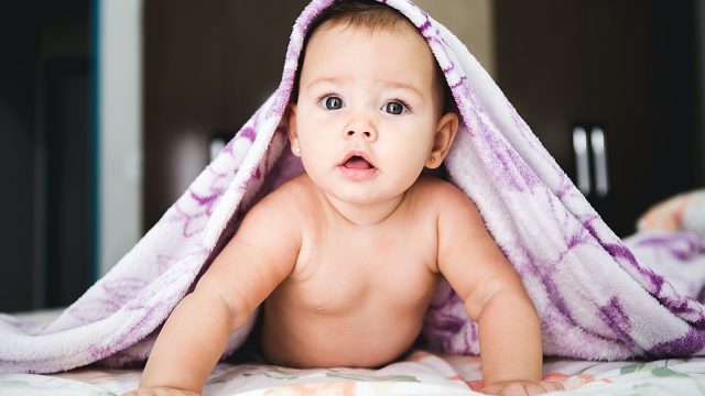 baby under purple blanket